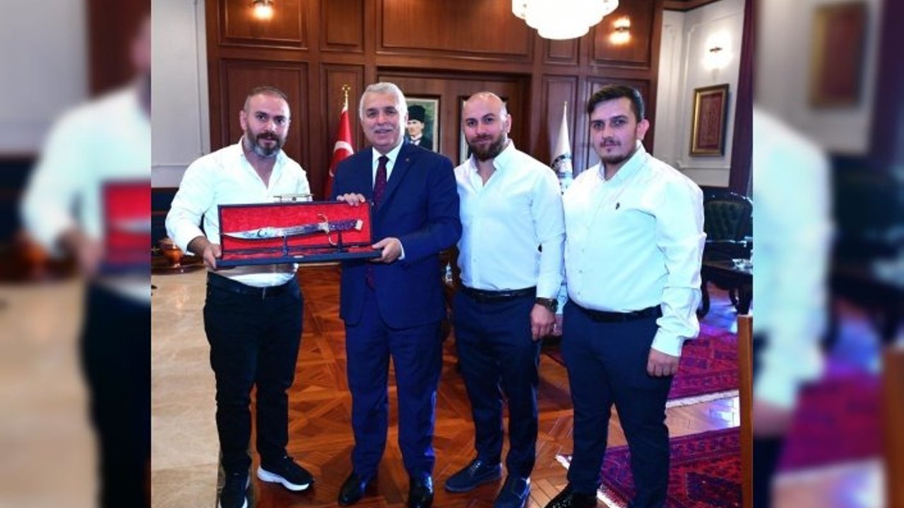 SÜRMENELİ BIÇAK VE KILIÇ USTASI ÖZYİĞİT KARDEŞLERDEN VALİ YILDIRIM’A BORDO MAVİ İŞLEMELİ KILIÇ